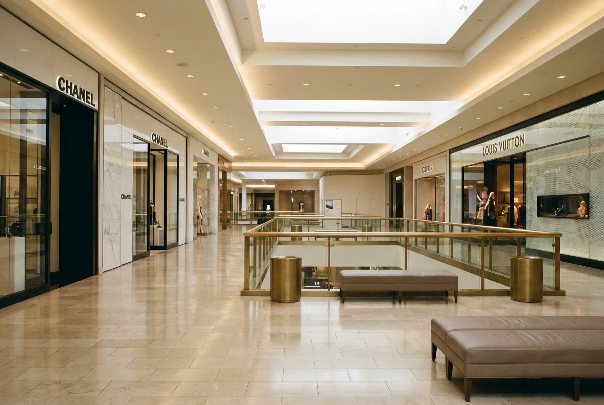 Interior of South Coast Plaza in Costa Mesa, luxury mall with travertine floors, brass railings, warm natural light