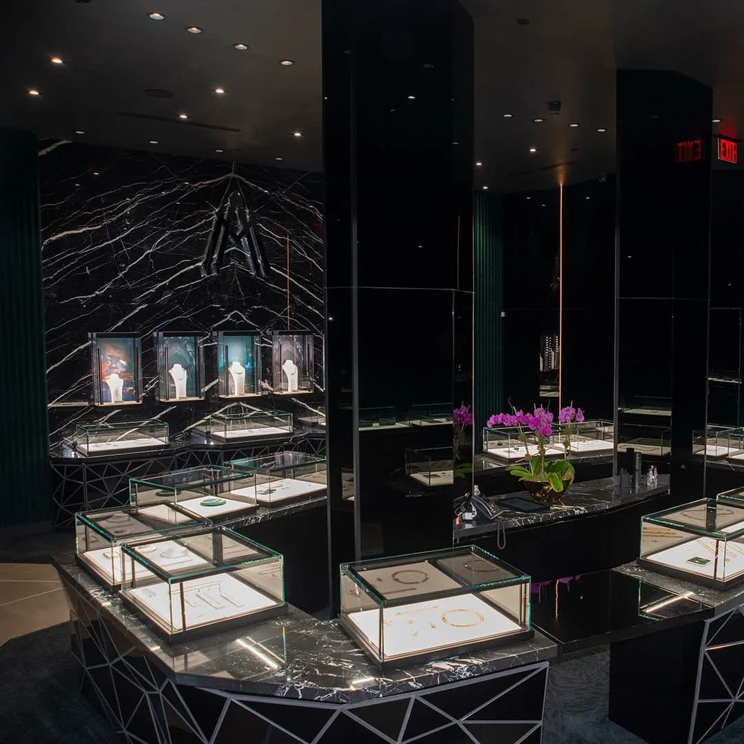 The Alex Moss New York SoHo flagship, with lit display cases and the monogram on black marble
